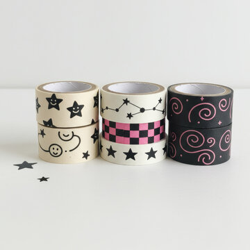 Adhesive decorative tape rolls featuring stars, constellations, and swirls, ideal for, crafting, and stationery, minimalist white background.