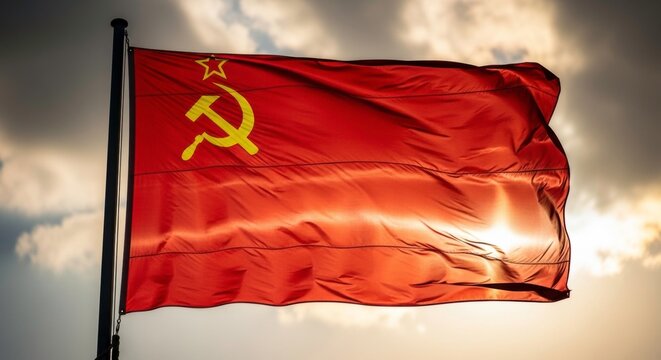 crimson soviet flag fluttering with hammer and sickle against a cloudy sky