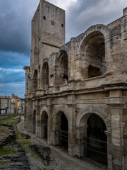 Fototapeta premium Arches of the Roman Amphitheater in Arles with medieval tower