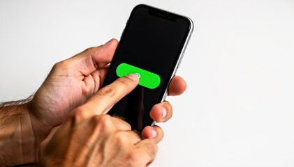 Fototapeta premium Touchscreen Interaction: A close-up shot of a hand interacting with a sleek smartphone, finger poised to tap a vibrant green button, symbolizing activation and digital connection.