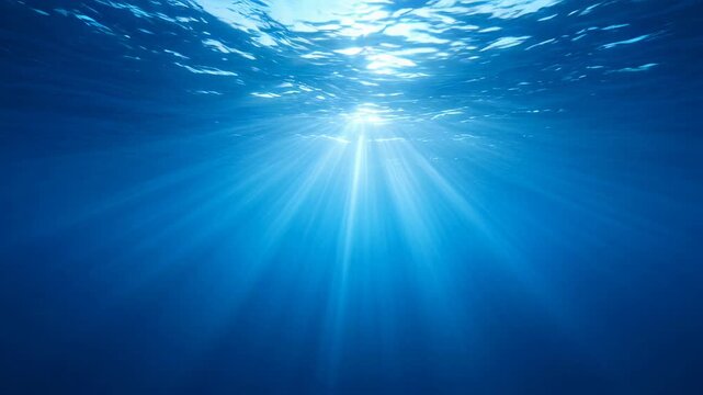 Bright natural sun rays illuminate serene deep blue ocean water, creating breathtaking mysterious underwater scene. Captivating light beams penetrate depths, revealing amazing profound wonder