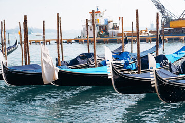 Fototapeta premium Gondolas rest at a dock in Venice during a sunny day with calm waters