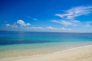 Fototapeta premium Wide Angle View of a Pristine White Sand Beach and Crystal Clear Turquoise Ocean Under a Vibrant Blue Sky in Balabac, Palawan, Philippines