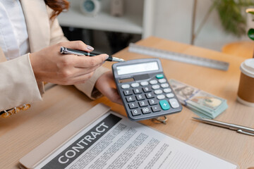 Fototapeta premium A real estate agent and a client are discussing and pointing at a housing contract document during a property purchase meeting, showing agreement details and financial negotiation about home ownership