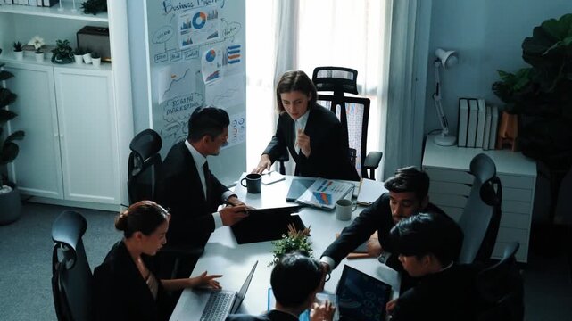 Top view of smart manager looking at financial statistic on tablet at meeting room. Group of diverse business people working together to analyze investment data on table with notebook. Directorate.