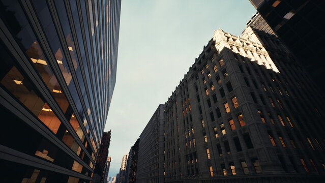 dusk between narrow skyscrapers with glowing. historic stone facades and glass towers frame sky, warm interior lights visible through grid of windows, cinematic