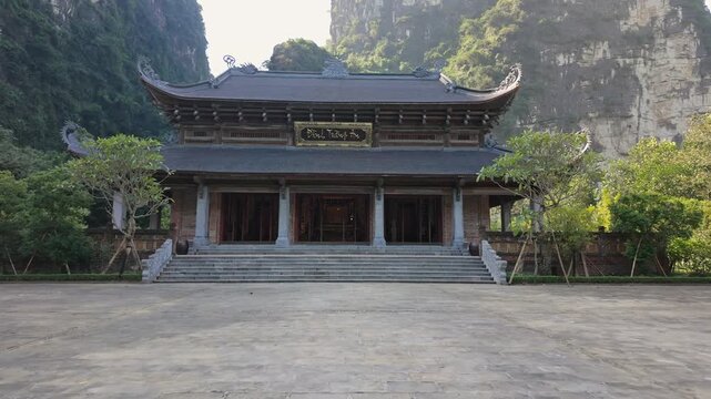 A scenic view of a Pagoda in Trang An, Ninh Binh, Vietnam. The pagoda's architecture and serene setting attract tourists and locals for spiritual reflection.
