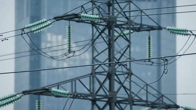 Electric power transmission tower with insulators and wires in urban area
