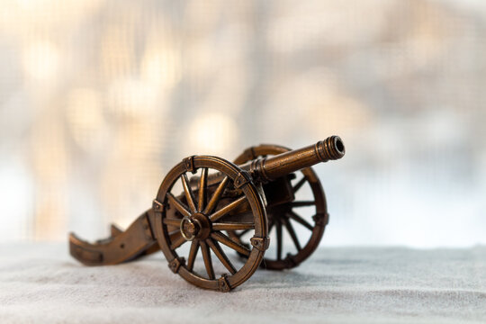 A miniature antique cannon on a light surface with blurred background for historical concepts and decorative purposes