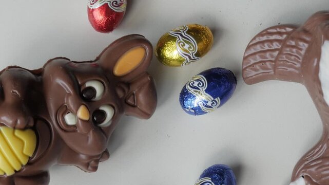 Chocolate bunny and Easter eggs on a white surface, symbolizing joy