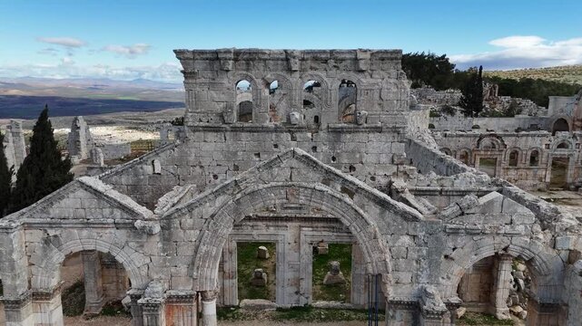 Cinematic drone perspective of the ancient facade of Saint Simeon church in Syria, a significant archeological site from the early Christian period