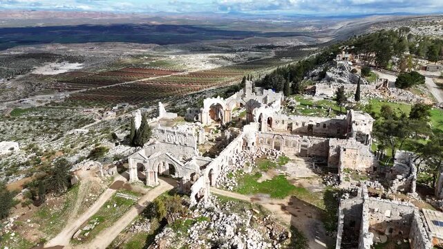 Cinematic drone of the ancient Saint Simeon church ruins, a significant Byzantine heritage site in the Syrian countryside