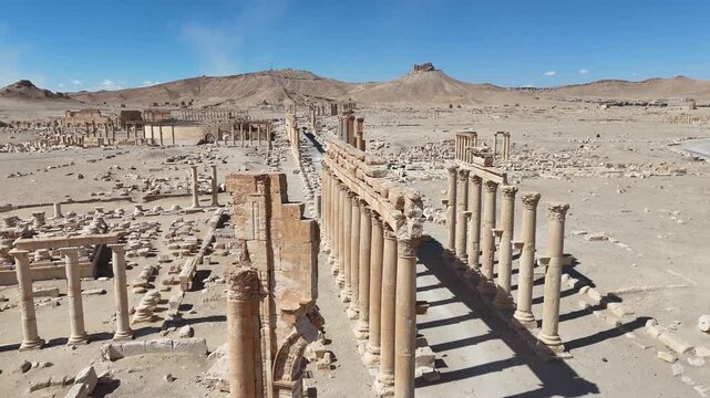 Aerial drone shot of the Great Colonnade in the ancient city of Palmyra, Syria, showcasing historic Roman architecture and archeological ruins