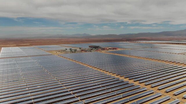 Aerial view showing repeating pattern of solar panels at the Ouarzazate solar power plant highlighting large scale renewable energy infrastructure in Morocco desert.