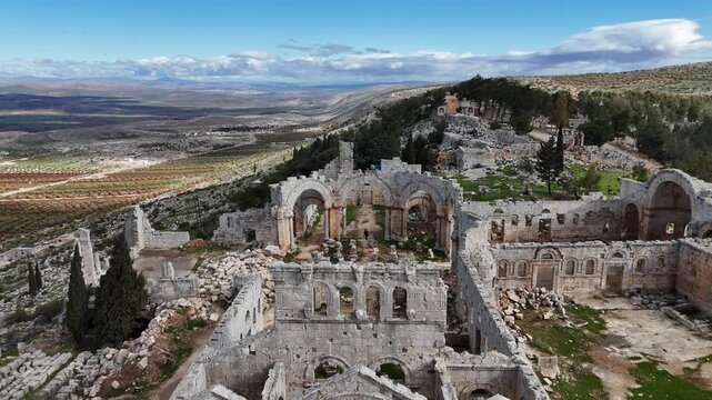 aerial drone view of historic St. Simons church ruins in Syria, featuring massive stone structures and scattered archeological debris