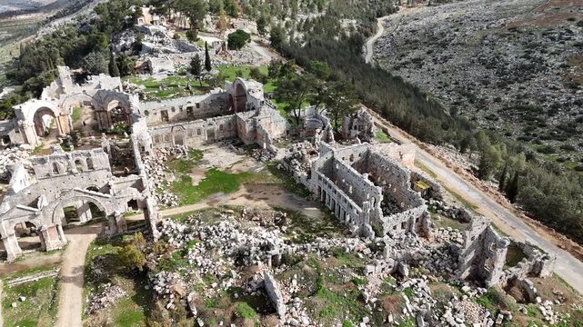 Aerial drone shot of the 5th-century Saint Simeon Stylites church ruins in Syria, showcasing ancient Byzantine architecture and stone arches