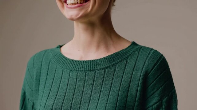 Woman in green sweater smiling.