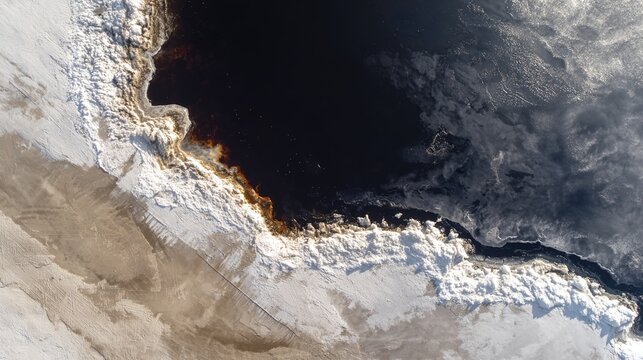 defiled. A vast white snowfield defiled by a sprawling black oil spill, aerial view. ESG reports, sustainability campaigns, designed for sustainability communications and ESG reporting.