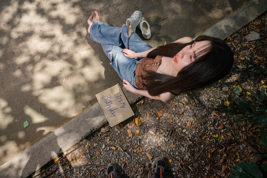 Woman Sitting Outdoors Holding Sign Celebrating Her 41st Birthday