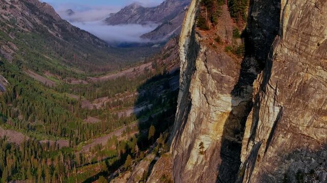 Dramatic granite cliff edge above Blodgett Canyon forest in Bitterroot Range Montana