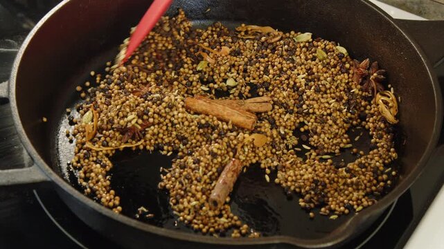 Whole spices toasted in cast iron pan, close-up Chettinad masala food