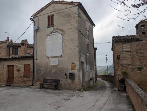 Vicolo storico in salita con edifici in mattoni e atmosfera tranquilla di un borgo italiano