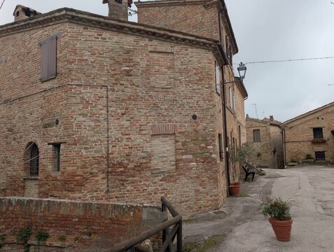 Stradina storica in mattoni con edifici antichi e atmosfera tranquilla in un borgo medievale italiano