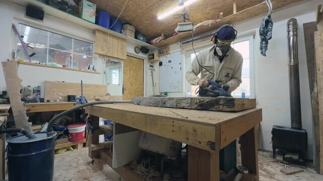 Woodworker in PPE Flattening Clamped Live Edge Slab with Electric Planer Static Wide Angle