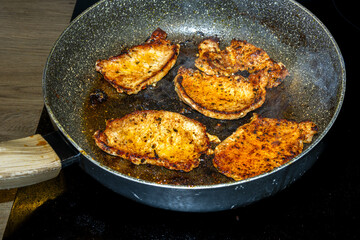 Fototapeta premium seasoned meat frying in pan on stovetop