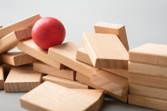 Red ball moving over rough wooden blocks path, overcoming barriers concept