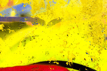 Weathered concrete wall with bright yellow graffiti paint and spray drips. Grungy substrate with overlapping street art layers and urban decay for edgy background designs. © Aleksandra Konoplya