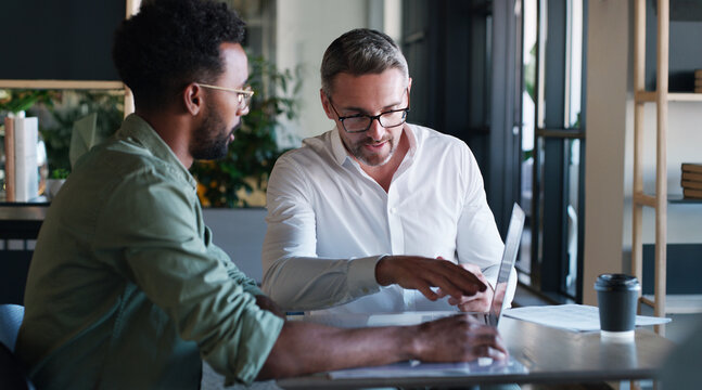 Mentor, reading and men with laptop, office and help with article on website, creative or journalism. Intern, learning and people with tech for story, teamwork and editing with manager in newsroom