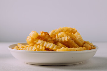 Crispy Crinkle-Cut Fries Piled High on a White Plate