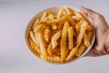 Crispy Golden Crinkle Cut Fries in a Bowl Held by a Hand