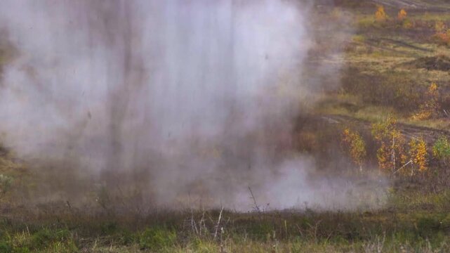 large ground explosion with dirt and smoke in open field