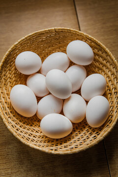 Organic eggs in a rustic basket on a countryside kitchen table