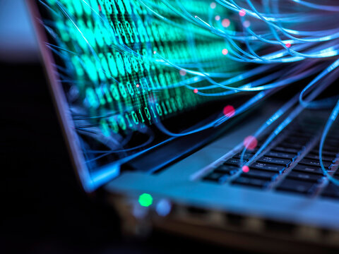 Computer virus and cyber attack visualized on laptop with binary code