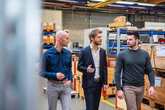 Employees having a business discussion in a warehouse environment