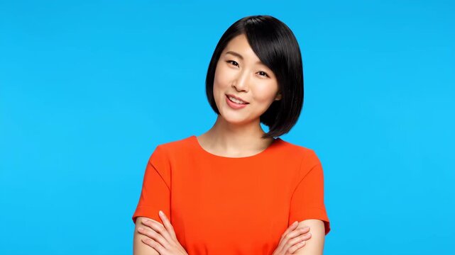 Portrait sequence of a happy adult asian woman with arms crossed smiling confidently at the camera. Isolated female model on a blue background for a corporate advertisement or website header