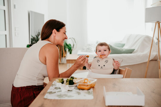 Mother feeding baby at home with loving bonding and quality time