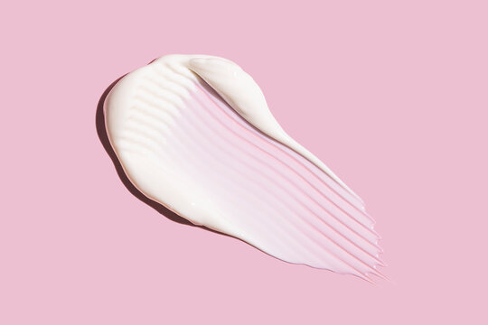 White skincare cream swatch with texture on pink background