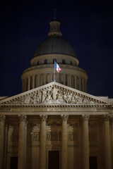 Pantheon in Paris illuminated at night with French flag on the roof