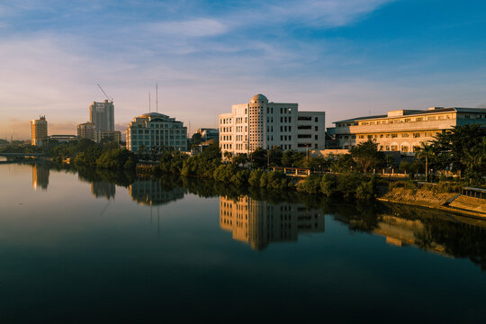 Aerial view of buildings reflecting on the still water of the river under the soft light of dawn, Iloilo City, Philippines.