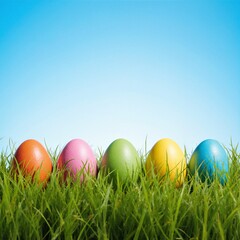 Fototapeta premium Colorful Easter Eggs Lined up in Grass Against a Clear Blue Sky Background