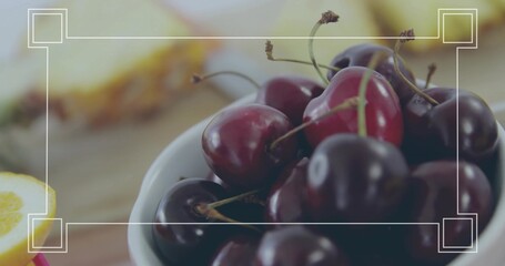 Showing white ceramic bowl holding red cherries with stems on wood table, lemon wedge, corner frame © vectorfusionart
