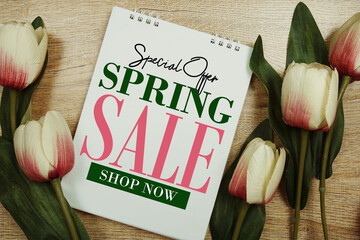 Spring Sale text with tulip flowers on wooden background