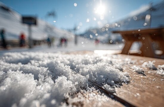 Snowy wooden table in a bright, sunlit mountain ski resort, bokeh background