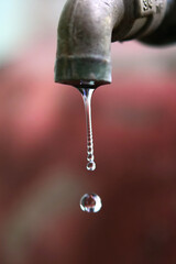 Water dripping from a faucet, emphasizing conservation
