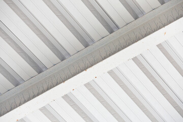 Obraz premium MODERN STEEL BEAM AND CORRUGATED METAL DECKING CEILING IN INDUSTRIAL BUILDING - ROOF STRUCTURE WITH GIRDER, JOIST, PANEL, GALVANIZED STEEL SHEET AND RIBBED ROOFING FOR CONSTRUCTION AND ARCHITECTURE
