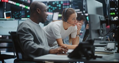 Two Professional Brokers Analyzing Big Data Trends on Multi Monitor Dashboard. Man Gestures Towards...